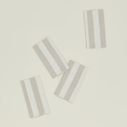These Hawkins New York Essential Striped Placemats, set of four, are elegantly arranged on a light beige surface, embodying easy living.