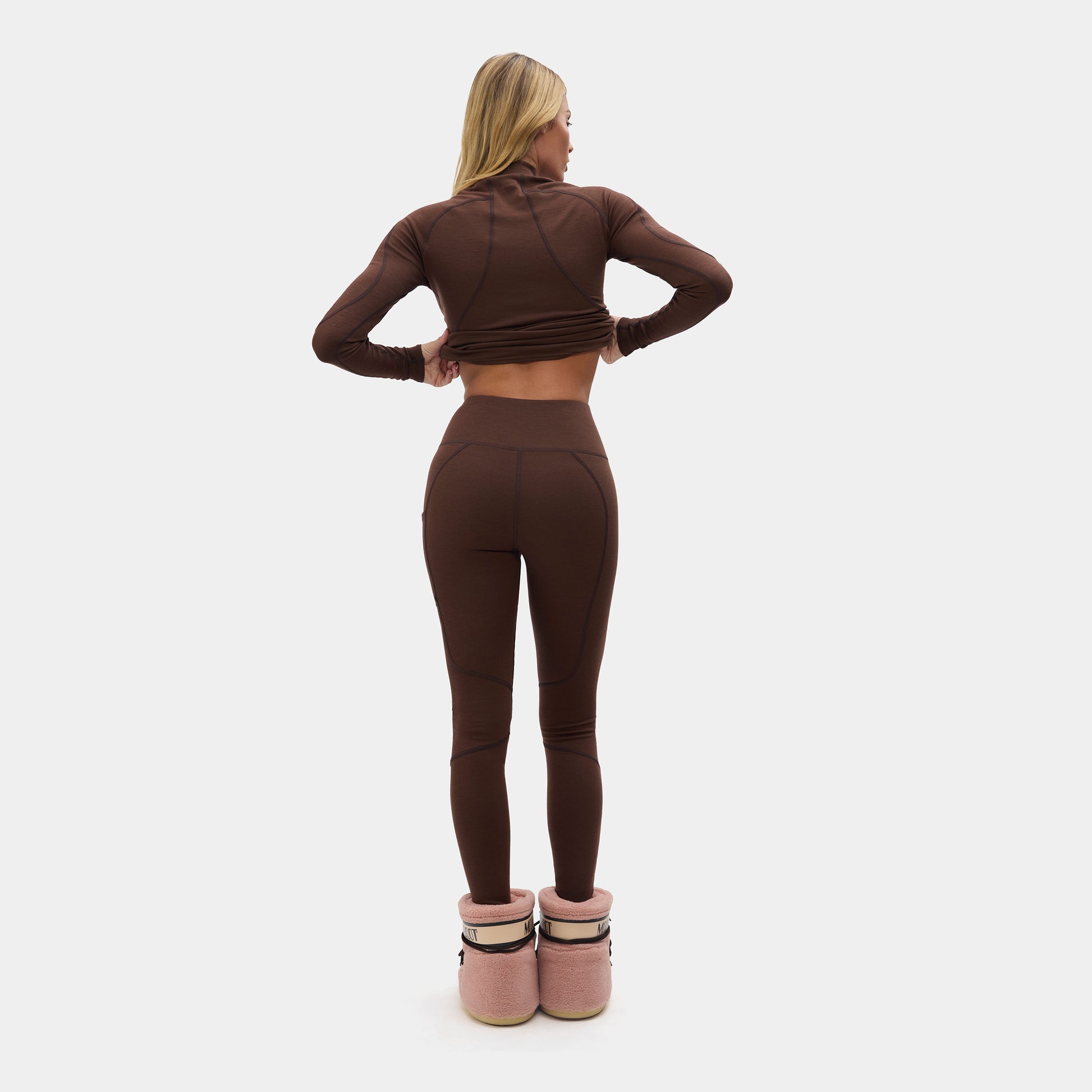 Woman wearing a brown outfit with Halfdays leggings with pink shoes on a white background