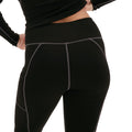 A person wears Halfdays' Hallie Merino Legging, which features black fabric with gray seams, constructed from a midweight blend. They're seen from the back against a white background.