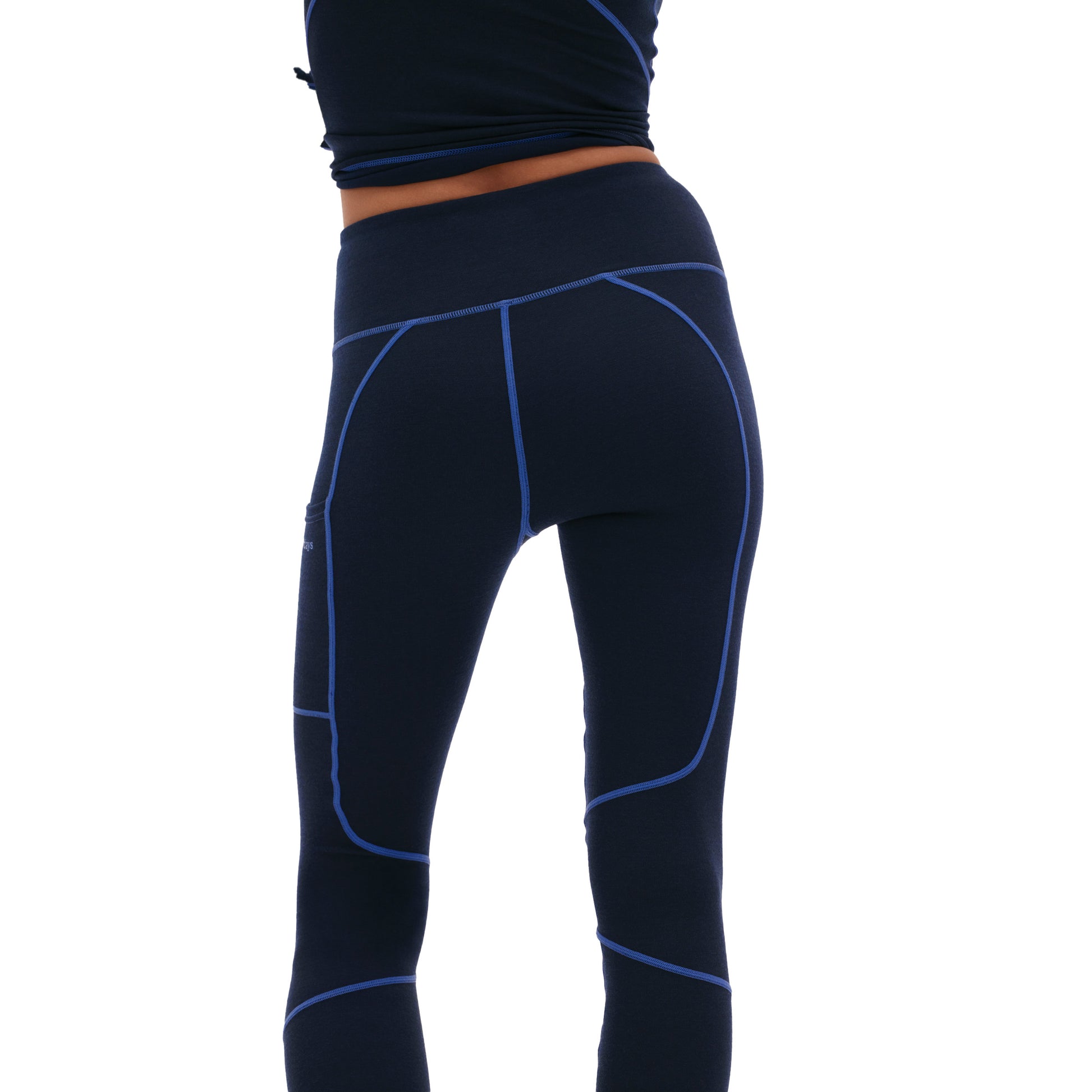 The image shows someone from behind wearing Halfdays' Hallie Merino Legging, featuring a midweight blend in navy blue with contrasting blue seams.