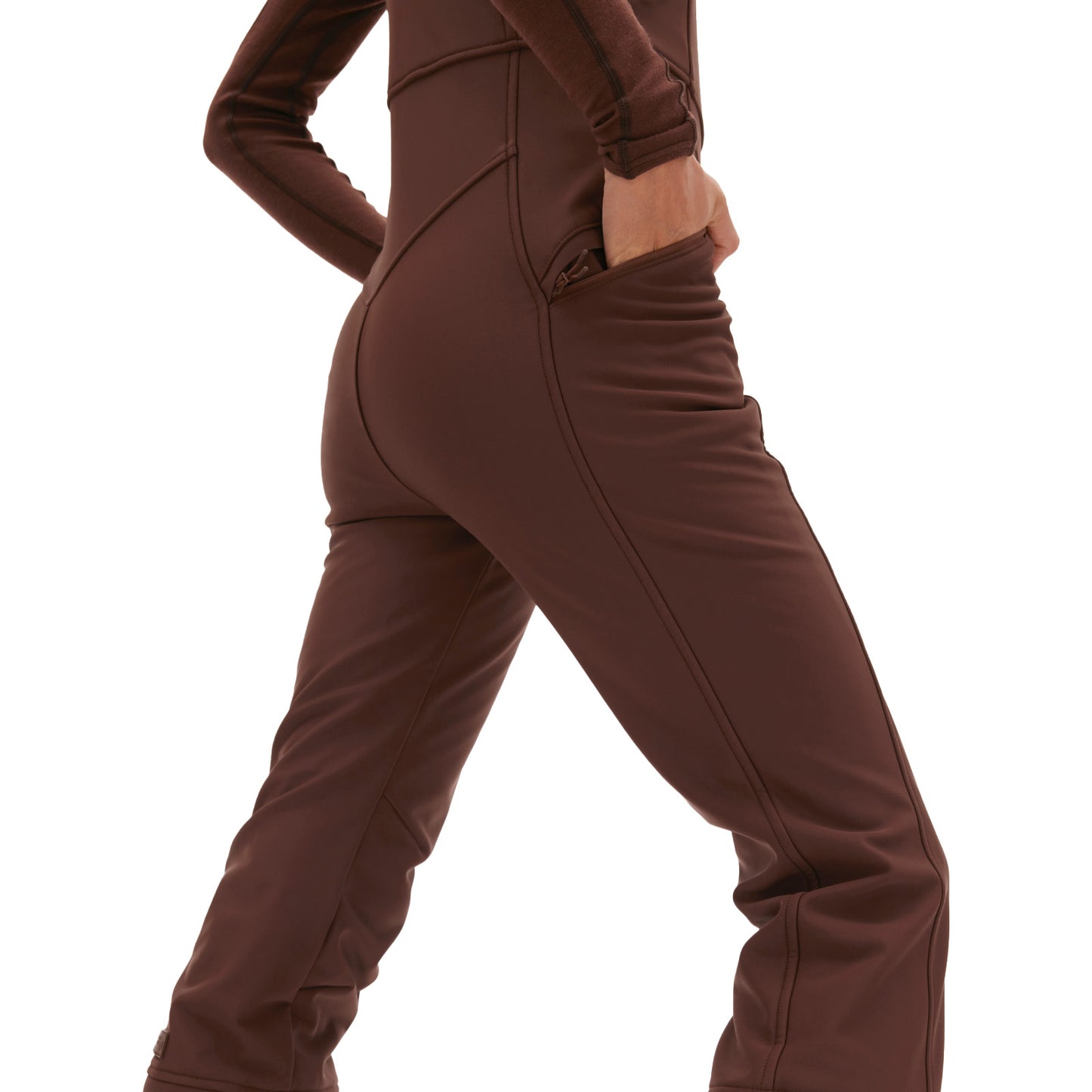 A person in the Isabel Soft Shell Bib Pant by Halfdays, featuring a slim fit and hands in pockets, viewed from the side.