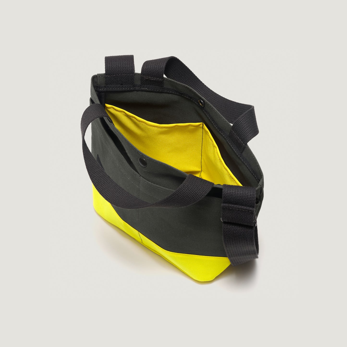 Introducing the New York Tote Small by Bags in Progress, Special Edition in Forest Green/Yellow, featuring two black handles, a shoulder strap, and a visible yellow interior pocket.