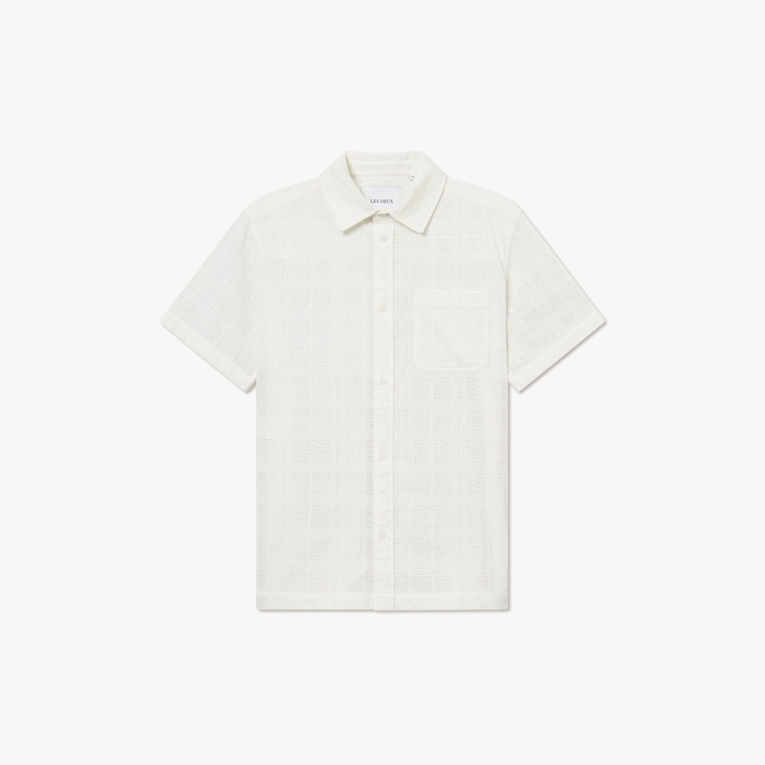 The Les Deux Charlie SS Shirt is a white short-sleeve button-up with vintage style, featuring a subtle checkered pattern and single chest pocket, shown on a plain white background.
