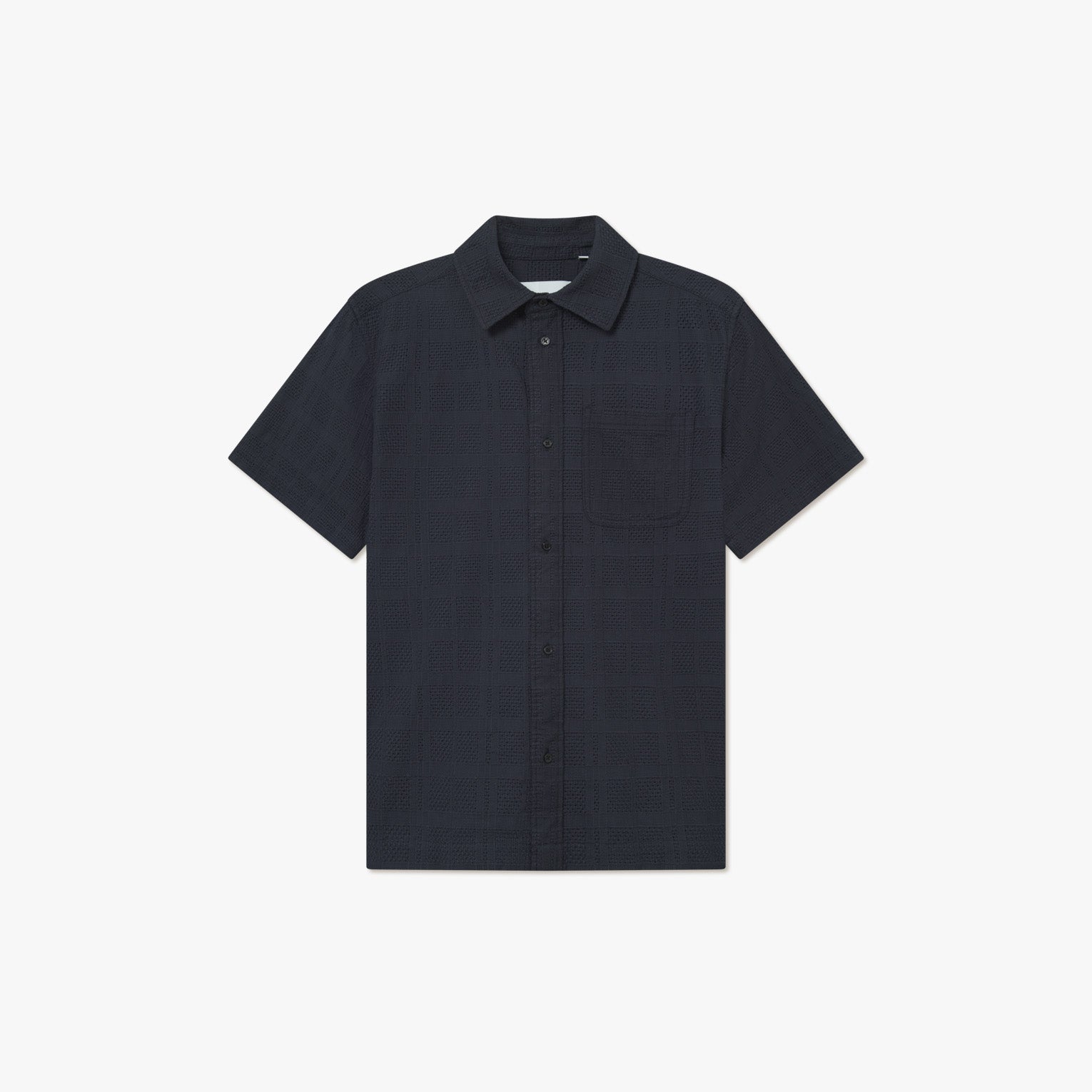 The Charlie SS Shirt by Les Deux is a dark navy short-sleeve button-up with vintage styling, a collar, and single chest pocket, shown against a plain white background.