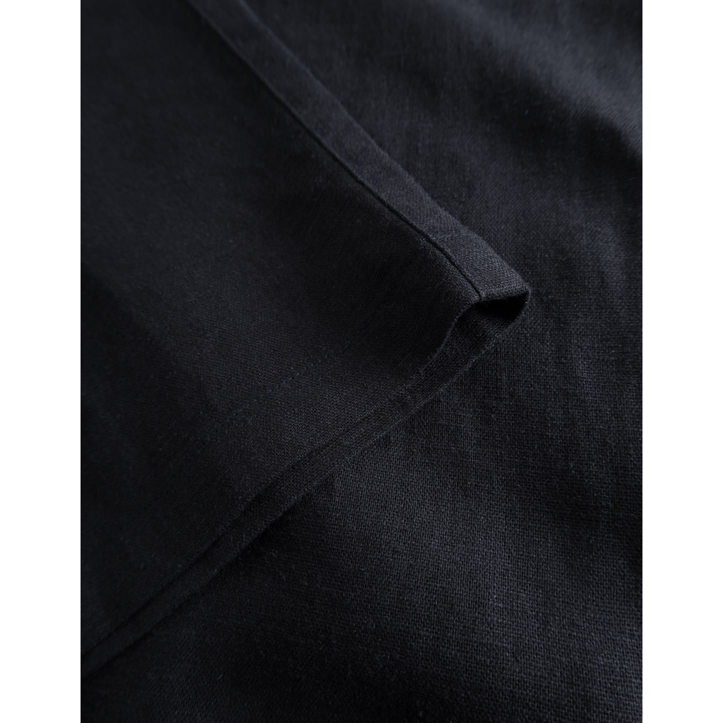 Close-up view of a Les Deux Patrick Linen Pants, Dark Navy breathable material texture showing the folds and weave detail.