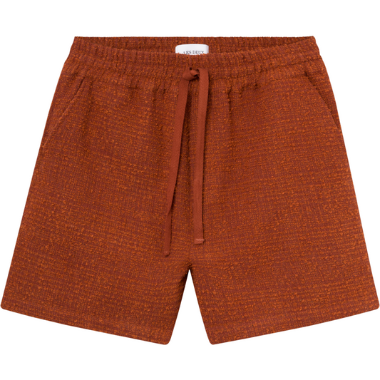 Kevin Boucle Shorts in Court Orange by Les Deux crafted from recycled polyester with a visible white Les Deux brand label at the waistband, displayed on a plain background.