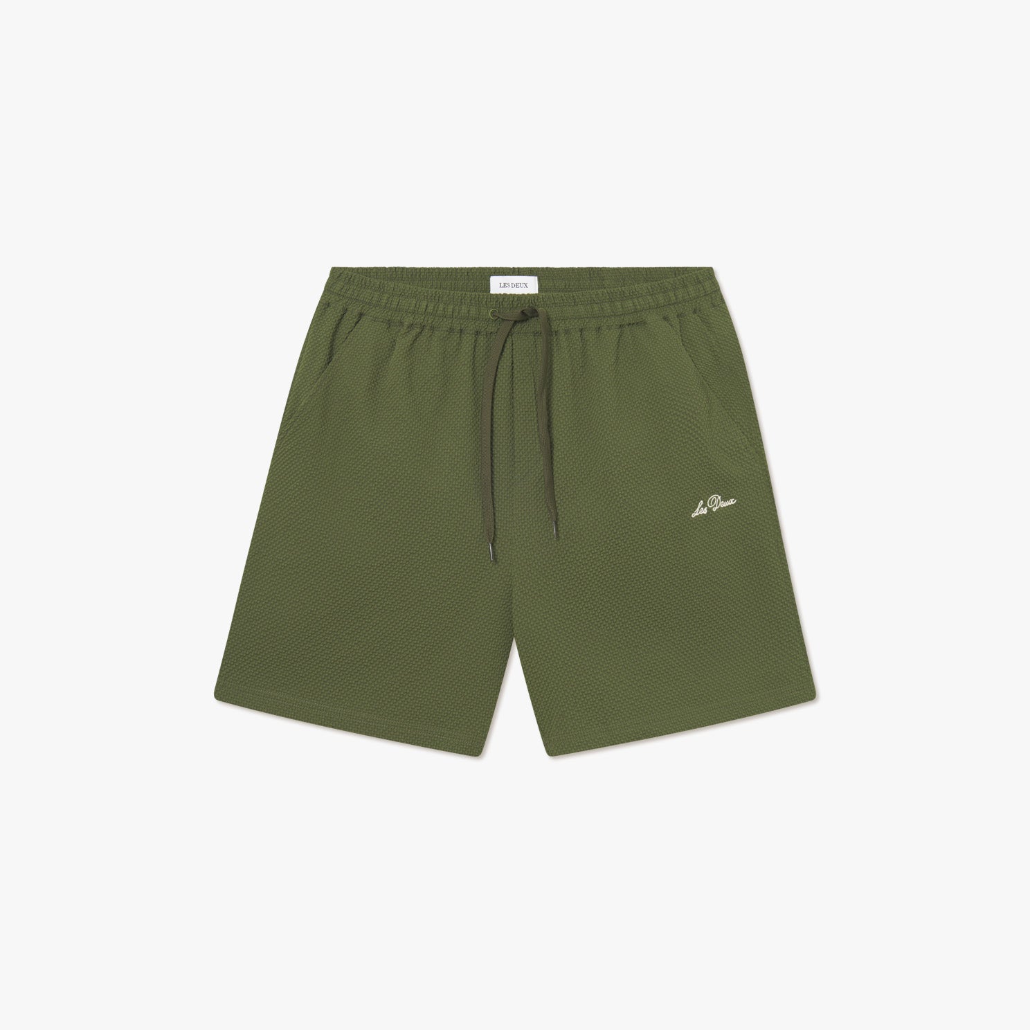 Les Deux Stan Seersucker Swim Shorts 2.0 in Chive Green feature mesh fabric, an elastic drawstring waist with black drawstring, and a small white logo on the left leg, displayed on a white background.