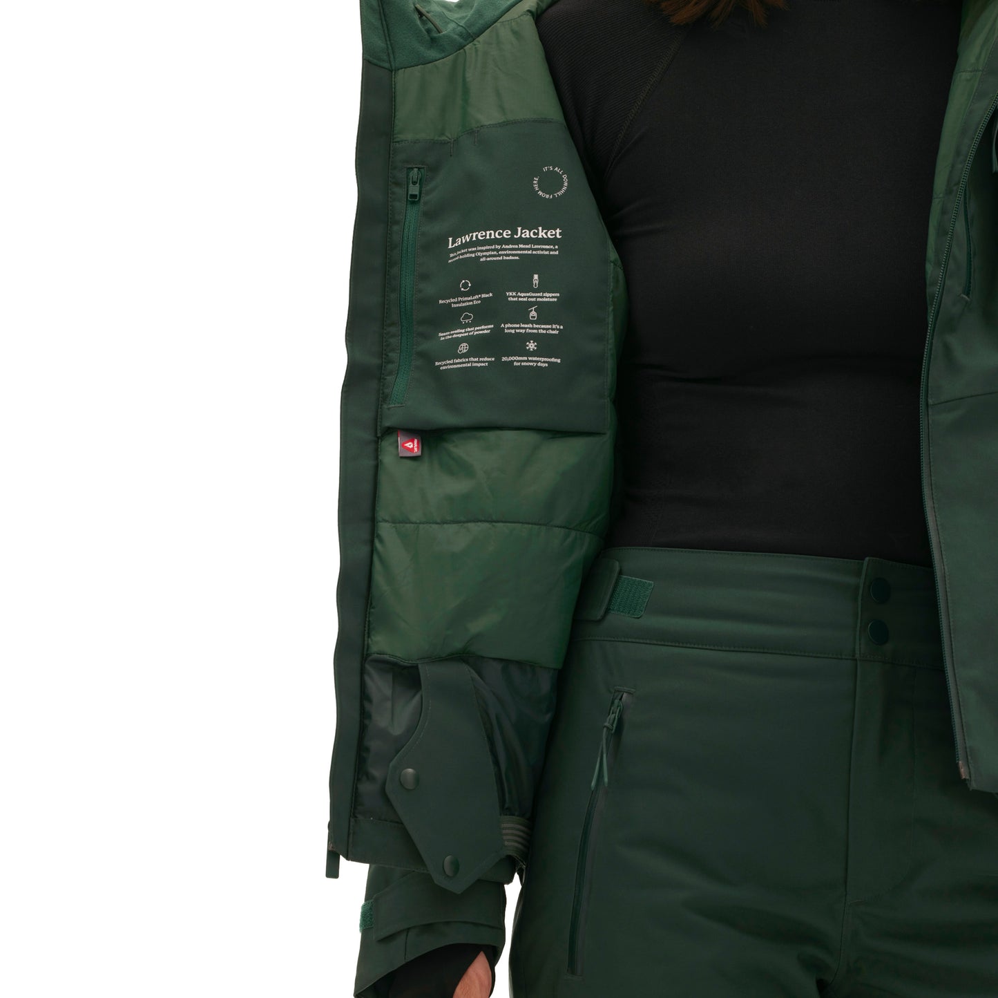 A woman is wearing the Lawrence Jacket by Halfdays, a dark green insulated ski jacket, with the label visible on the inner lining.