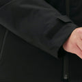 Close-up of a woman wearing the Halfdays Lawrence Jacket, a black insulated ski jacket featuring a Velcro strap on the sleeve.