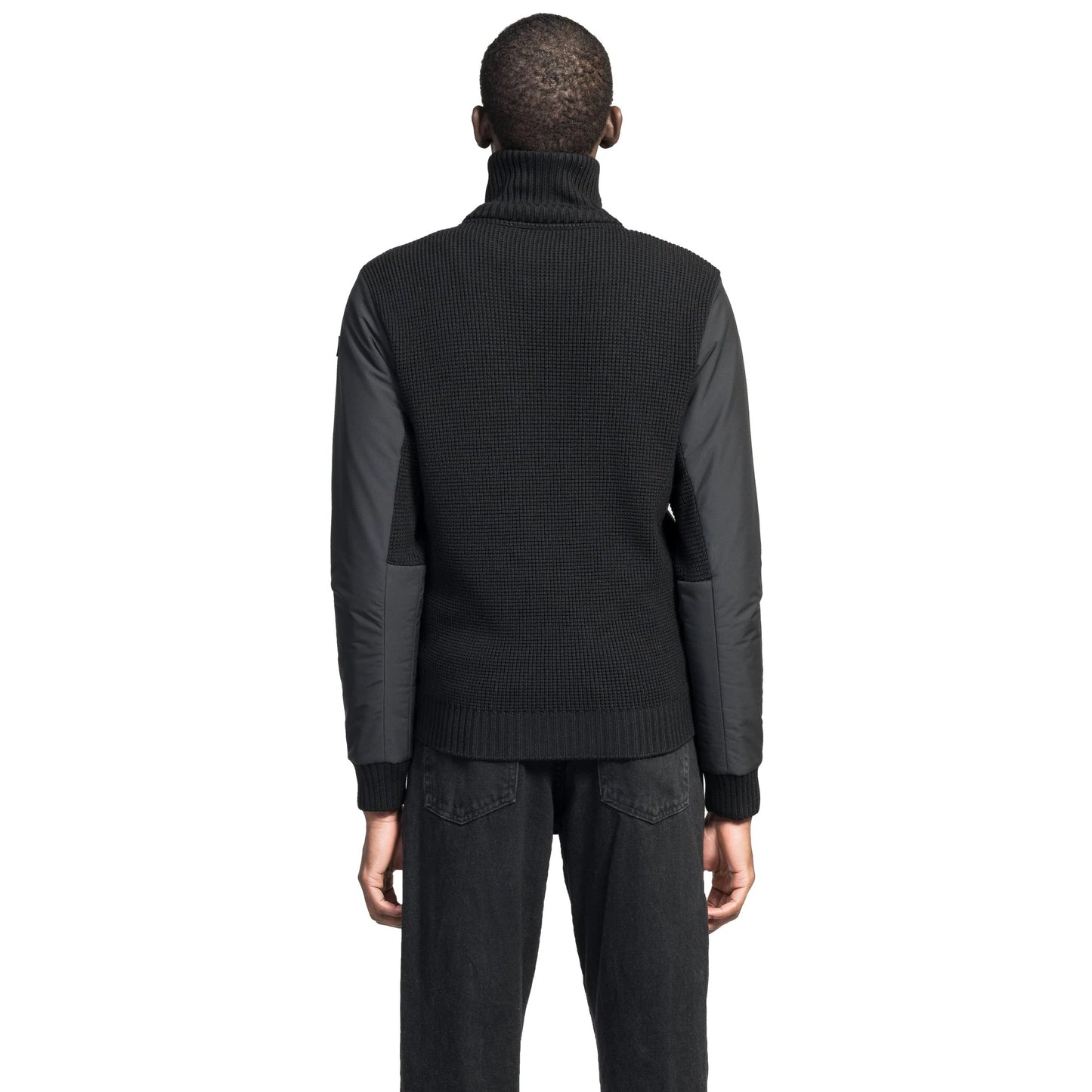 A person in a black Nobis Layton Men's Tactical Hybrid Sweater and jeans is shown from behind against a white background.