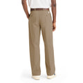 A person is shown from the back wearing Dockers Genderless 86 Original Pleated Chino in khaki with a brown belt, white sneakers, and a white shirt, set against a plain white background.