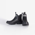 The Nimbus Chelsea Welly, by Barbour, is a pair of black rubber boots with a white Barbour logo on the front and a sturdy mudguard, displayed against a plain white background.