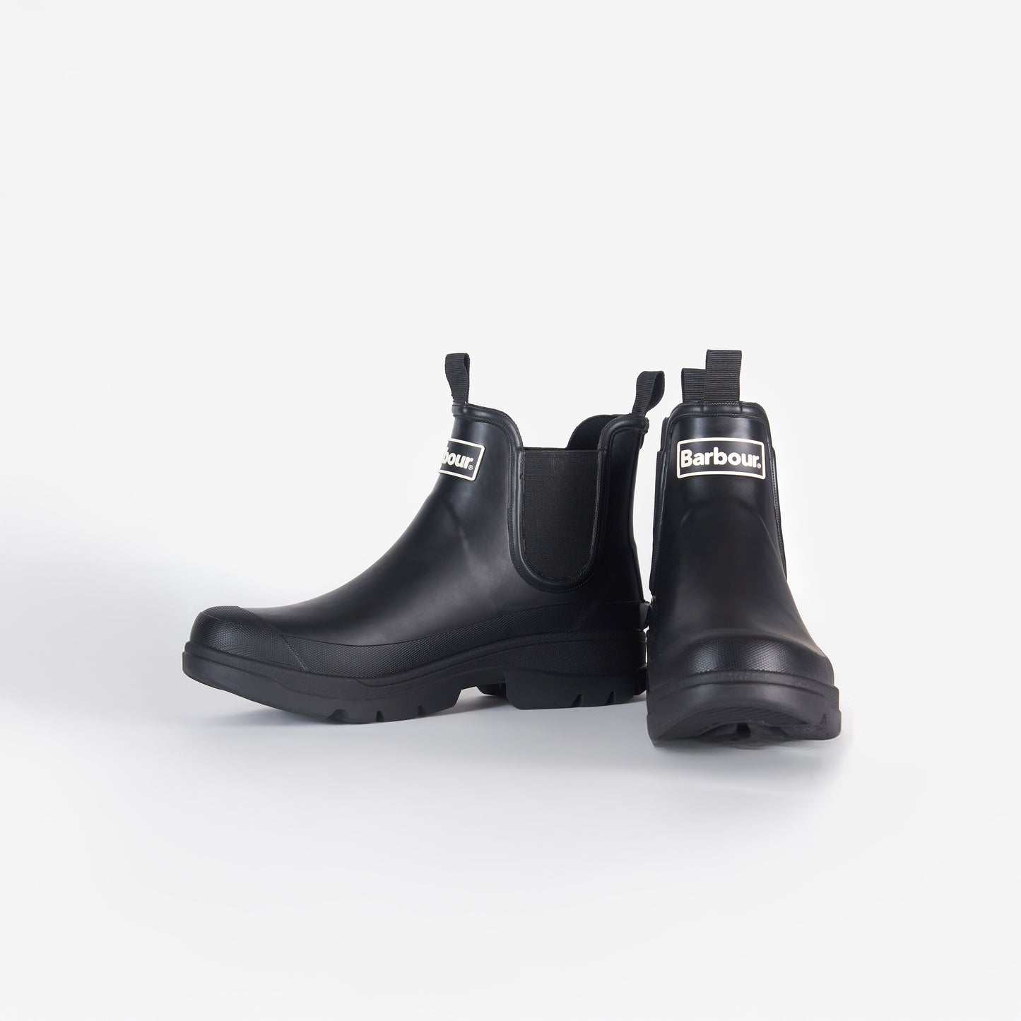 The Nimbus Chelsea Welly, by Barbour, is a pair of black rubber boots with a white Barbour logo on the front and a sturdy mudguard, displayed against a plain white background.