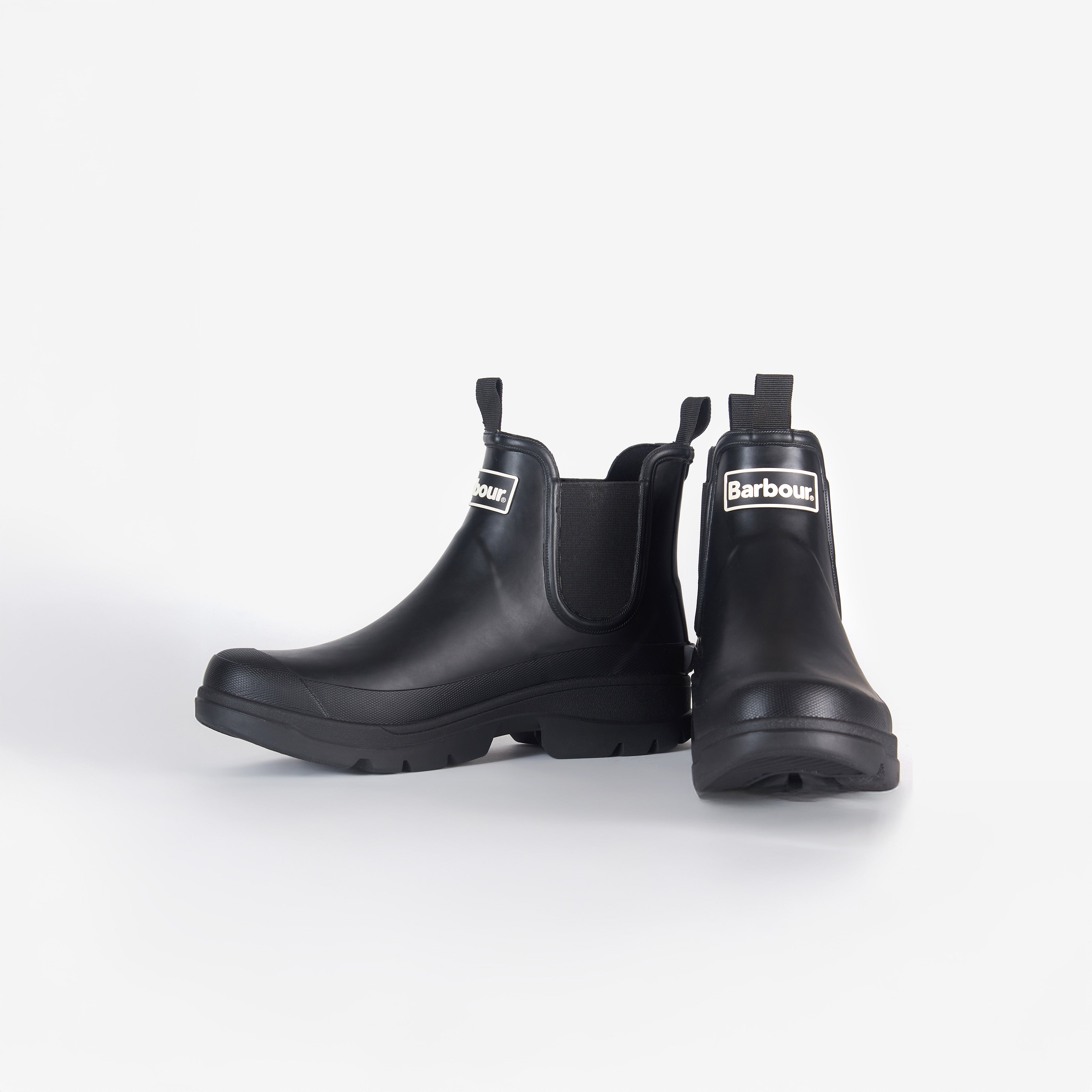 The Nimbus Chelsea Welly, by Barbour, is a pair of black rubber boots with a white Barbour logo on the front and a sturdy mudguard, displayed against a plain white background.