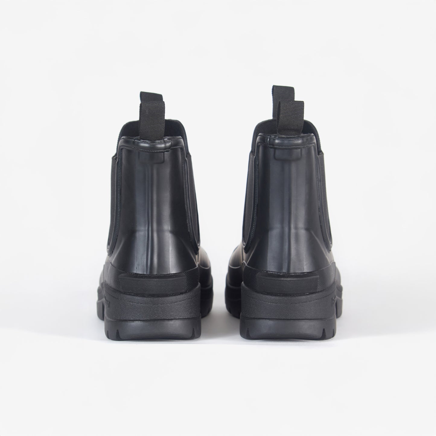 Rear view of Barbour's Nimbus Chelsea Welly in black, showcasing sleek pull tabs and a subtle mudguard, set against a plain white background.
