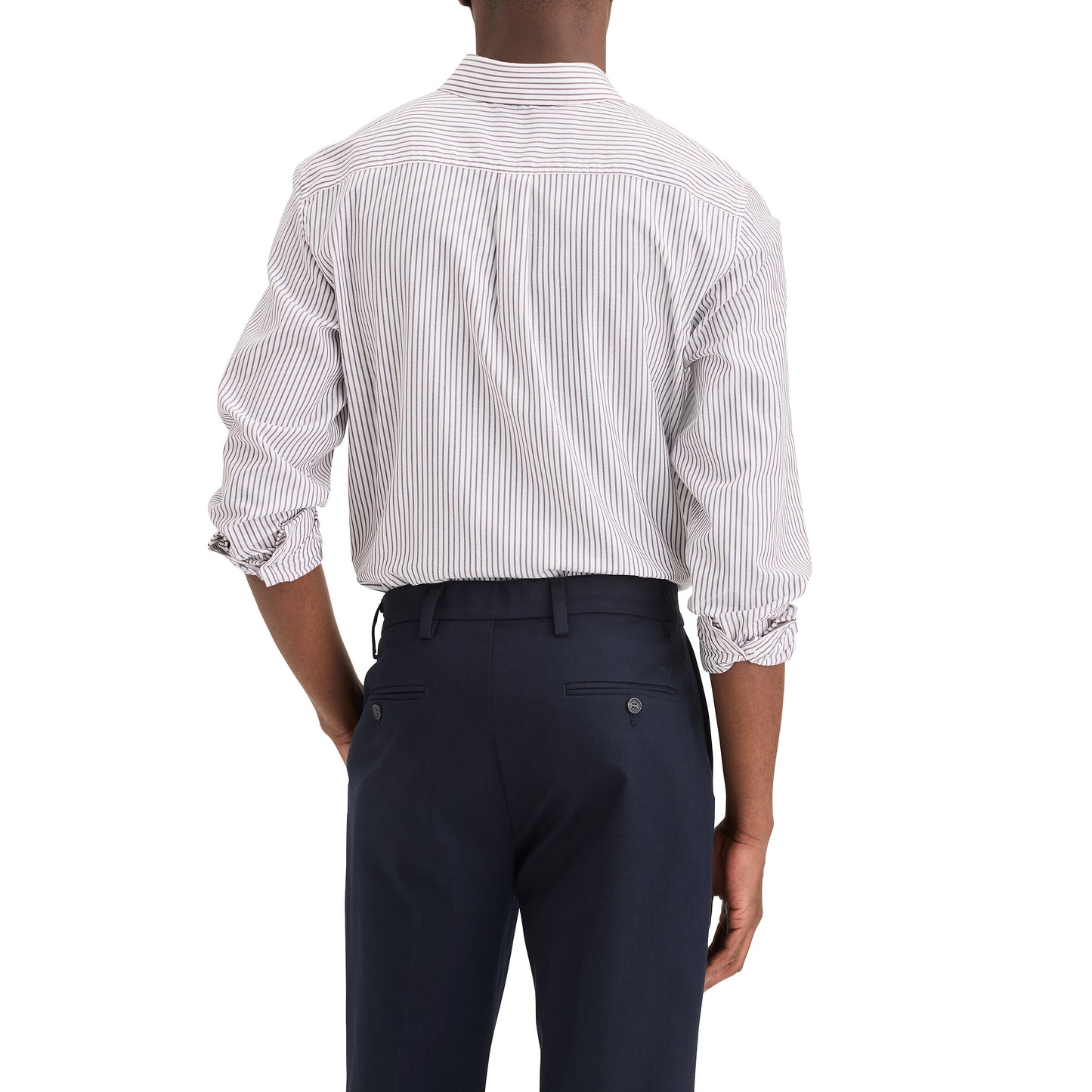 A man, seen from behind, wears a Dockers Men's Signature Shirt, LS with rolled-up sleeves and dark pants, standing against a plain white background.