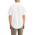 A person in a Dockers Men's Signature Shirt with Stain Defender, SS and beige pants made from Mechanical Stretch Twill stands with their back to the camera against a pristine white background.