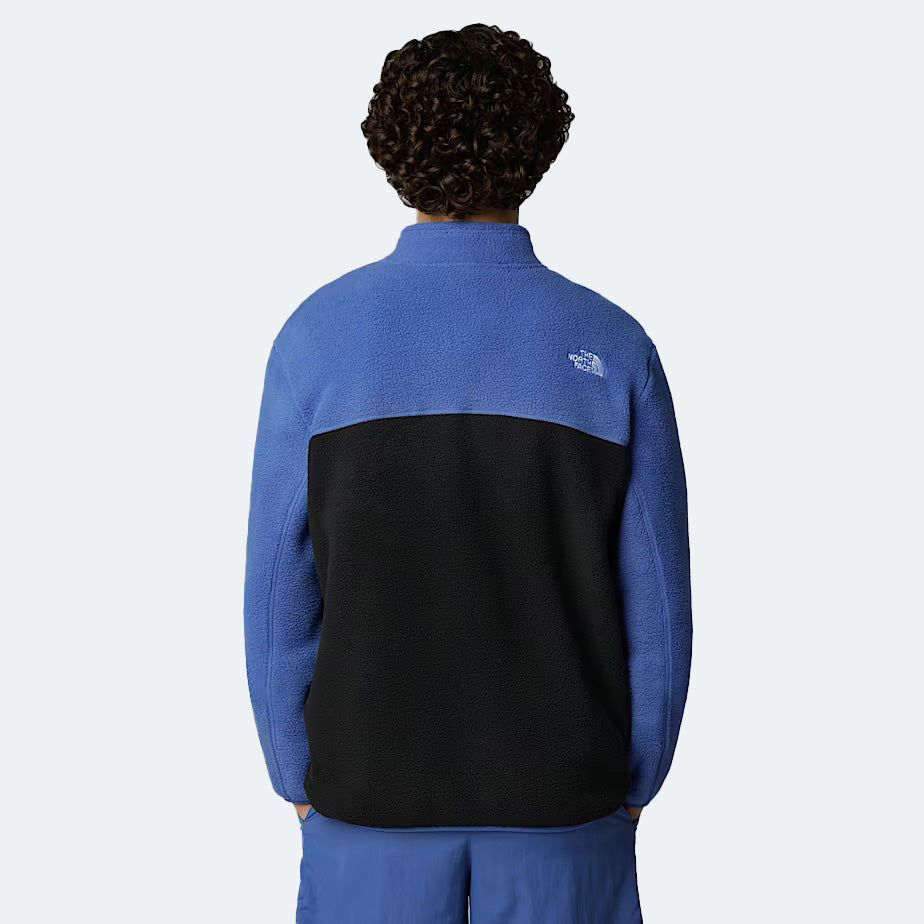 A person with curly hair, facing away from the camera, is wearing The North Face's M Yumiori Full Zip fleece jacket in two-tone blue and black, renowned for its warmth.