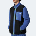 Against a light background, a person wears The North Face M Yumiori Full Zip jacket in blue and black. Green zippers add a pop of color while its midweight fleece keeps you warm on chilly days.