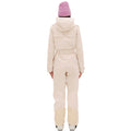 A person in a cream-colored Murphy Ski Suit by Halfdays and a pink beanie, stands with their back to the camera against a white background.