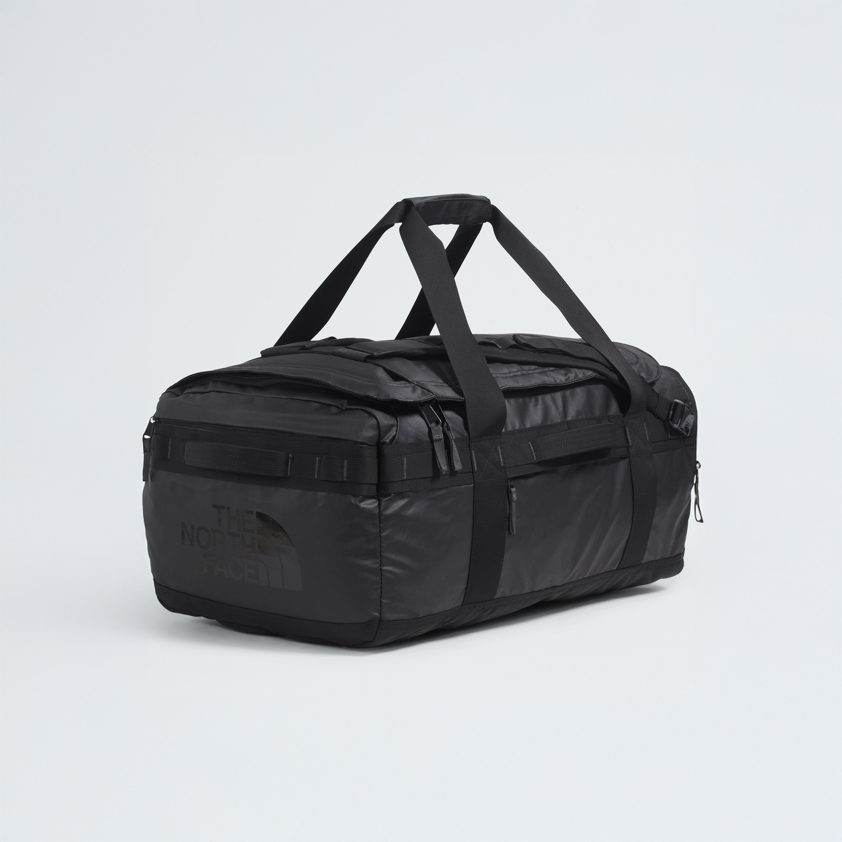 A black The North Face Base Camp Voyager Duffel - 62L with dual handles and zipper compartments, celebrated for its lightweight build, rests on a plain white background—a perfect travel companion.