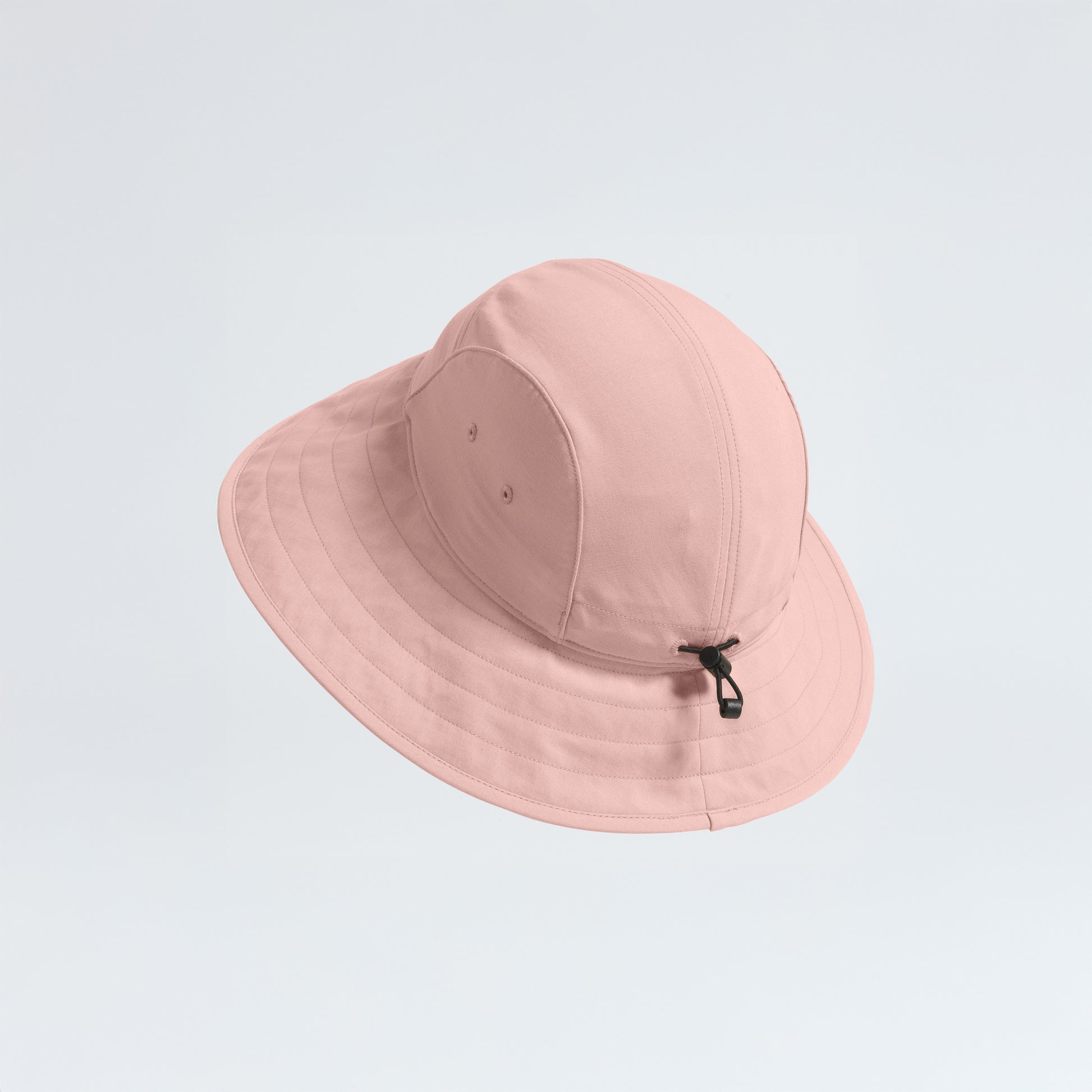 The North Face's W Class V Brimmer is a pink bucket hat with a wide brim for sun protection, made of quick-drying fabric and featuring a drawstring loop at the back.