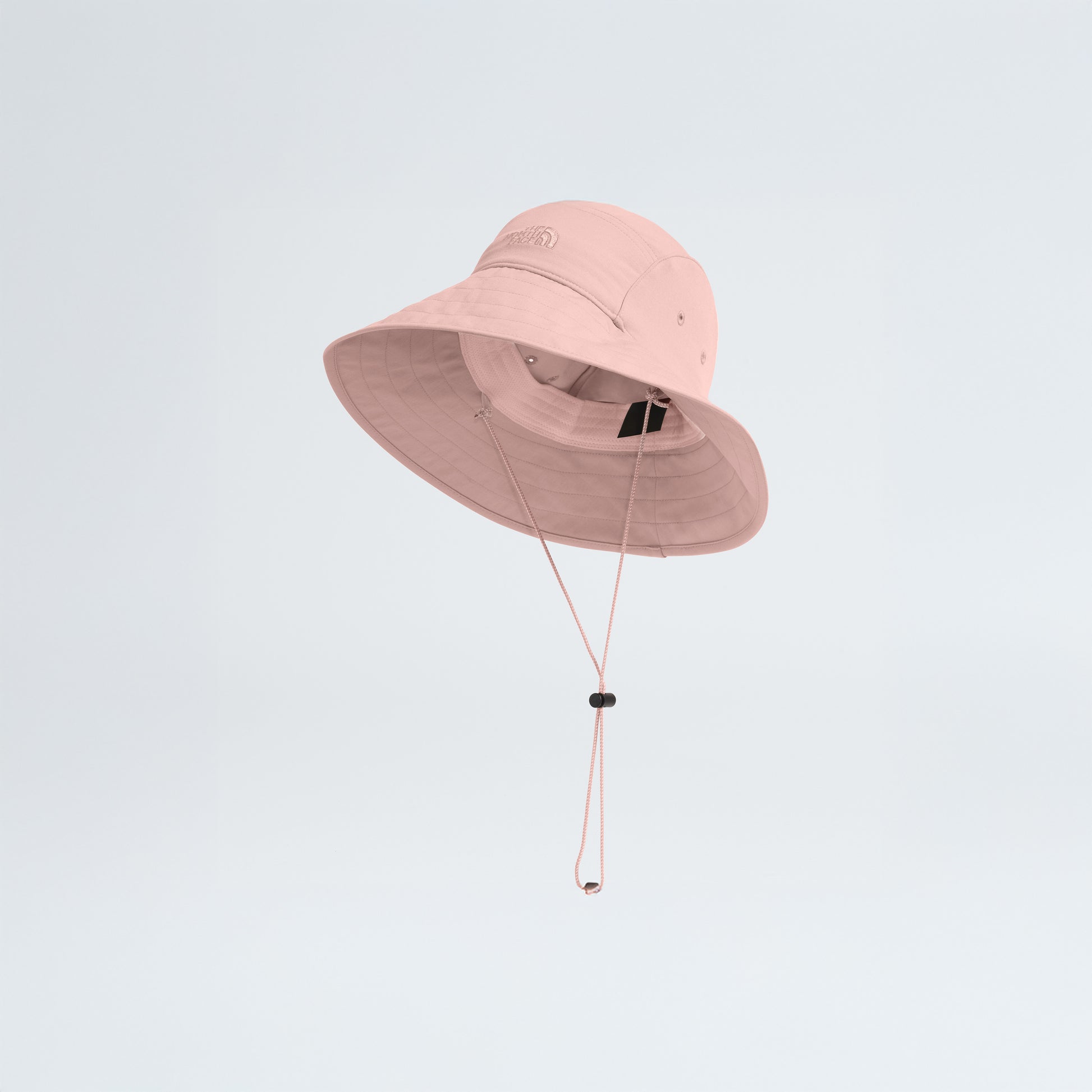 A pink W Class V Brimmer by The North Face, featuring a chin strap, is showcased floating against a plain white background. This stylish hat provides excellent sun protection, ideal for sunny days.