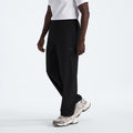 Someone in The North Face M North Dome Wind Pant with a white t-shirt and white sneakers, standing against a plain background.