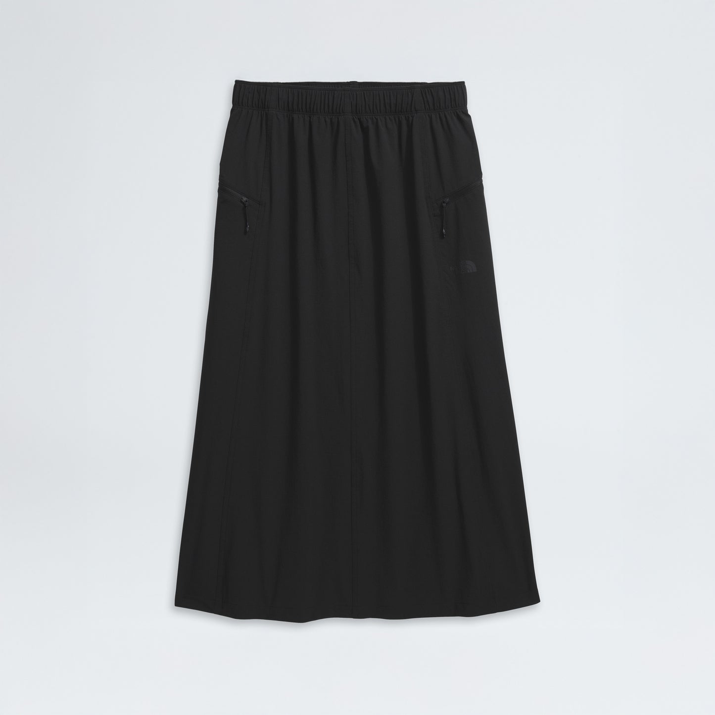The North Face's W North Dome Wind Skirt, a long black A-line design, features an elastic waistband and two zippered side pockets, showcased on a white background.