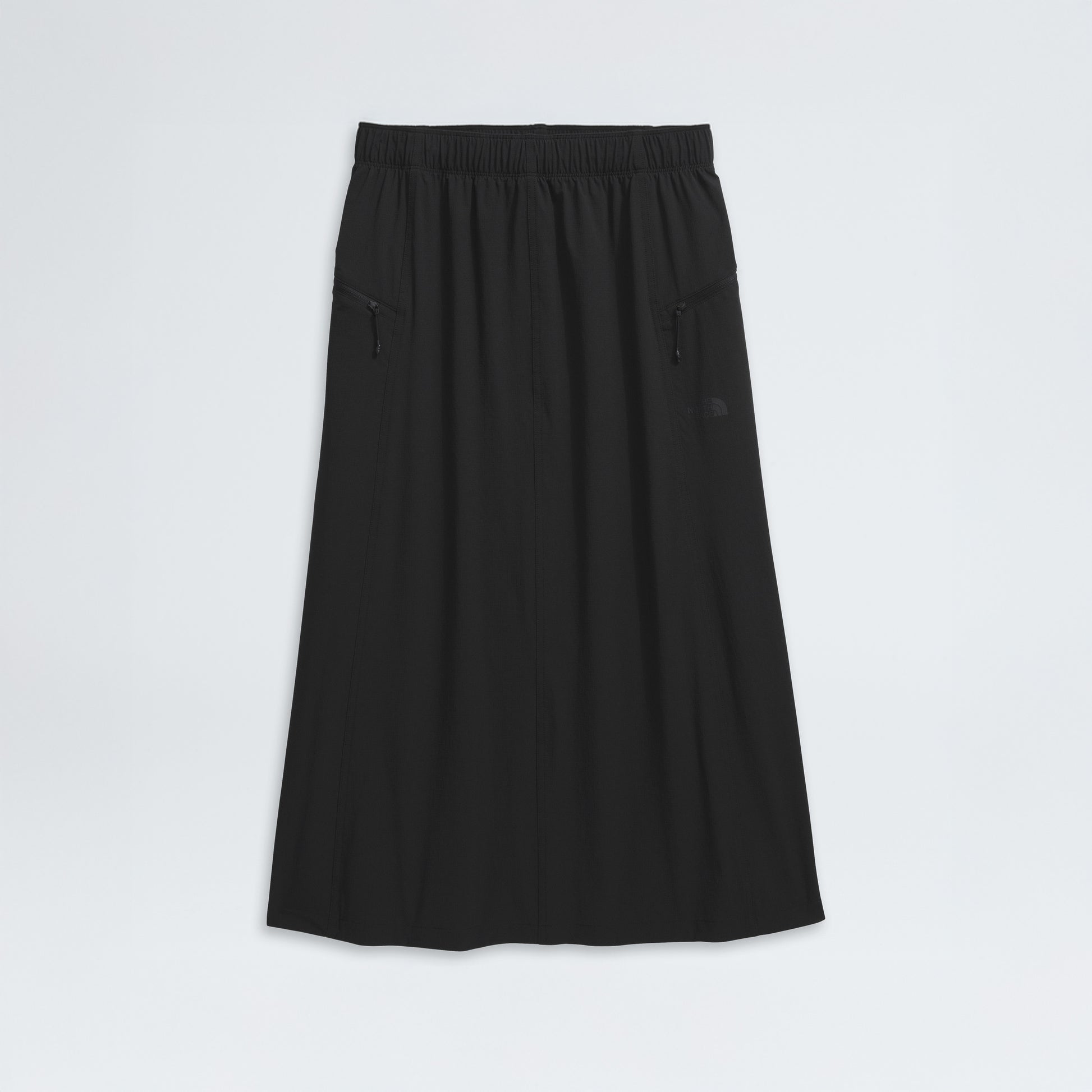 The North Face's W North Dome Wind Skirt, a long black A-line design, features an elastic waistband and two zippered side pockets, showcased on a white background.