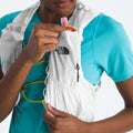 A person wearing a blue shirt adjusts their The North Face U Summit Run Vest 5, ensuring the bottles are secure in the front pockets for race day.