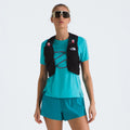 A person wore a turquoise athletic outfit with sunglasses and a black U Summit Run Vest 5 from The North Face, complete with water bottles.
