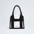 A black and white Base Camp Mini Tote features a patterned handle and "The North Face" logo on the front, crafted from recycled fabric for sustainability.