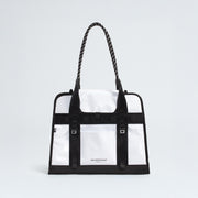 The North Face Base Camp Tote Bag features a durable white and black design, rope handles, black strap details, internal organization, and the brand logo on the front.