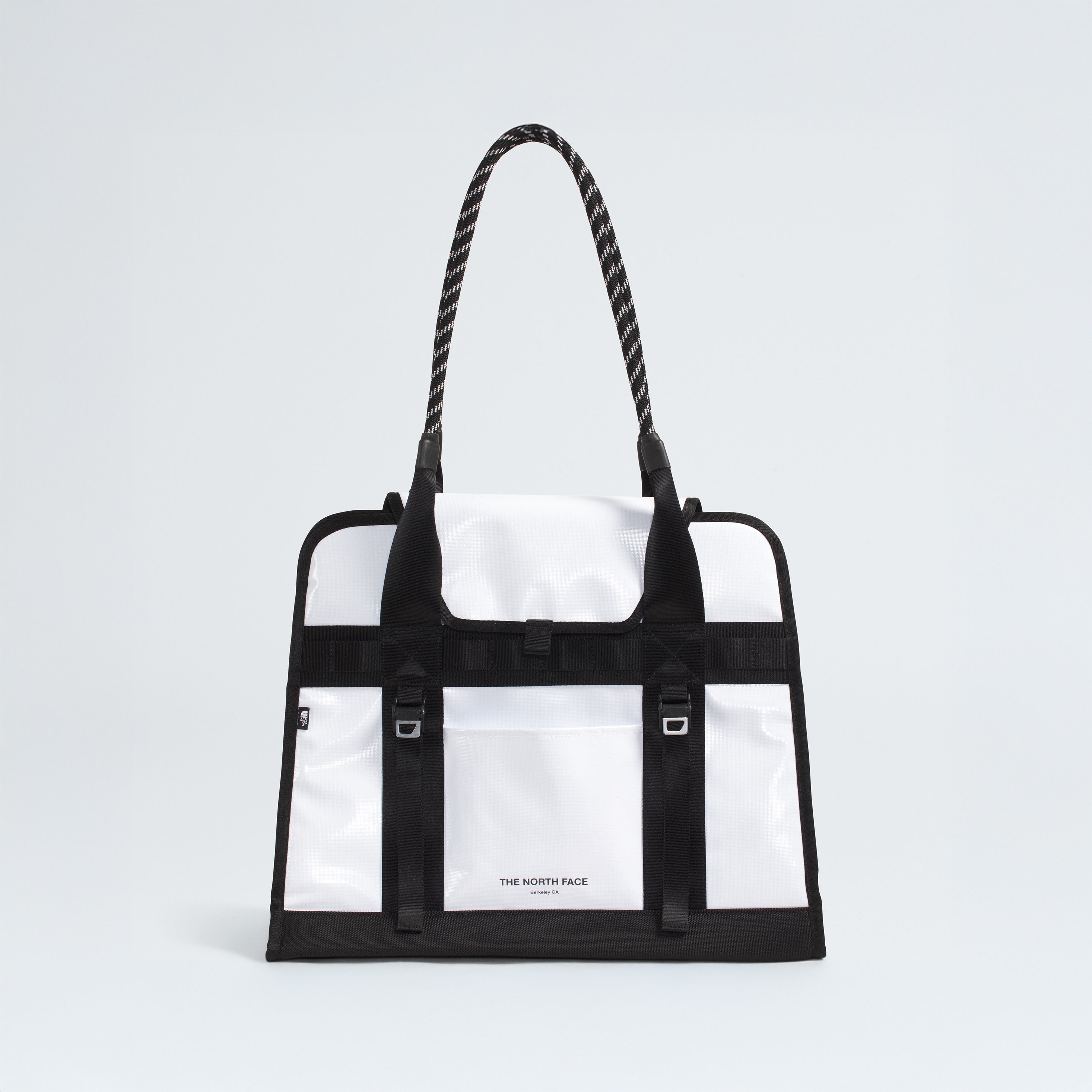 The North Face Base Camp Tote Bag features a durable white and black design, rope handles, black strap details, internal organization, and the brand logo on the front.