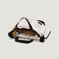 Open New York Tote Medium, Natural/Black from Bags in Progress on a light background, displaying contents like a newspaper, a white bottle, and a clear plastic bottle inside.