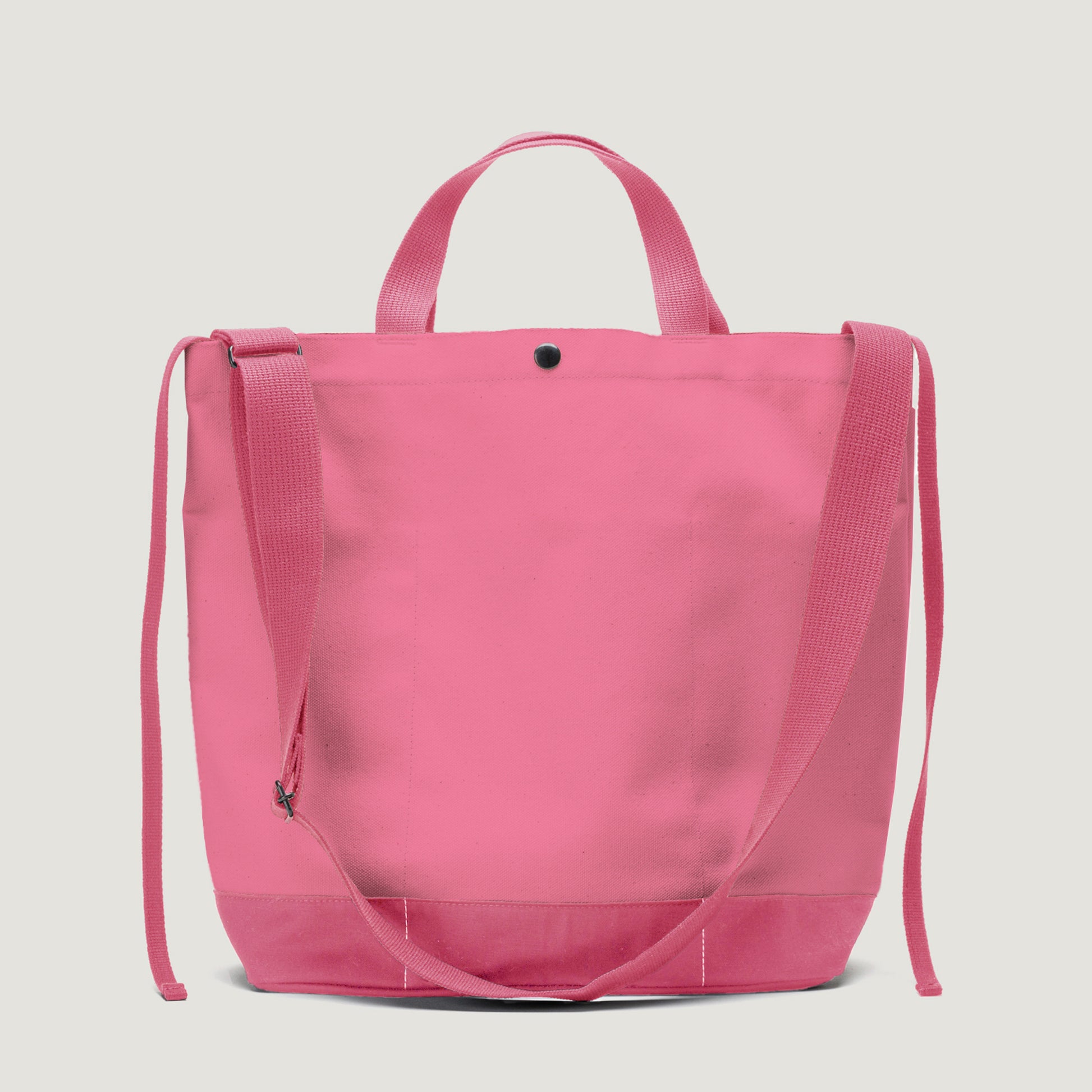 The Bags in Progress New York Tote Medium, Special Edition: Candy Pink, features dual handles, an open top, and an adjustable shoulder strap. It's displayed against a plain light background.