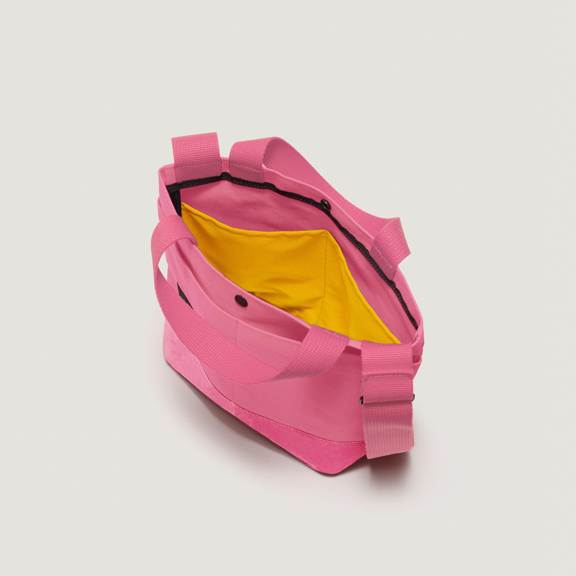 The Bags in Progress New York Tote Small, Special Edition: Candy Pink, features handy exterior pockets and a yellow interior pocket, shown from above against a plain white background.