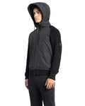 A person clad in the luxurious Hedge Men's Performance Hoodie by Nobis and black pants, standing sideways against a white background.