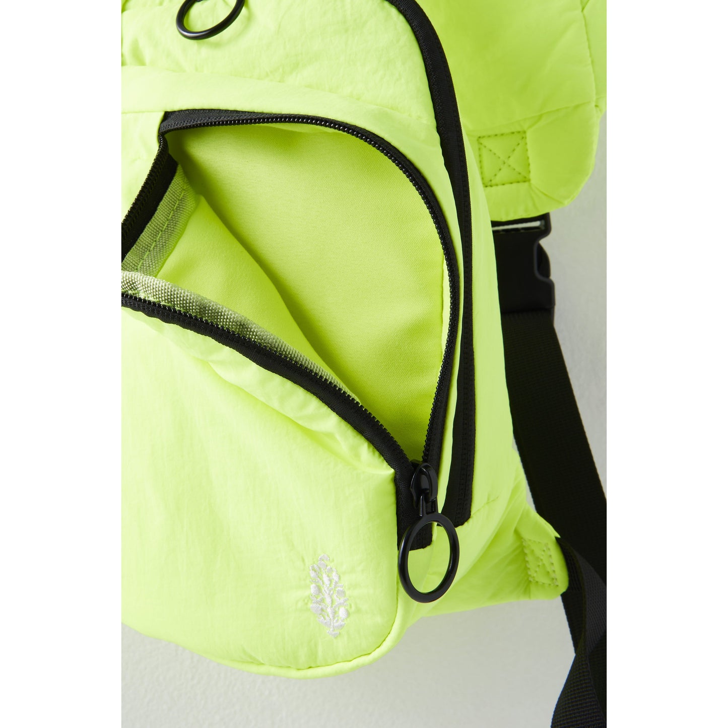 Bright neon green Renegade Sling bag with an open zipper revealing the interior, featuring a detailed Free People Movement logo and black trimming.