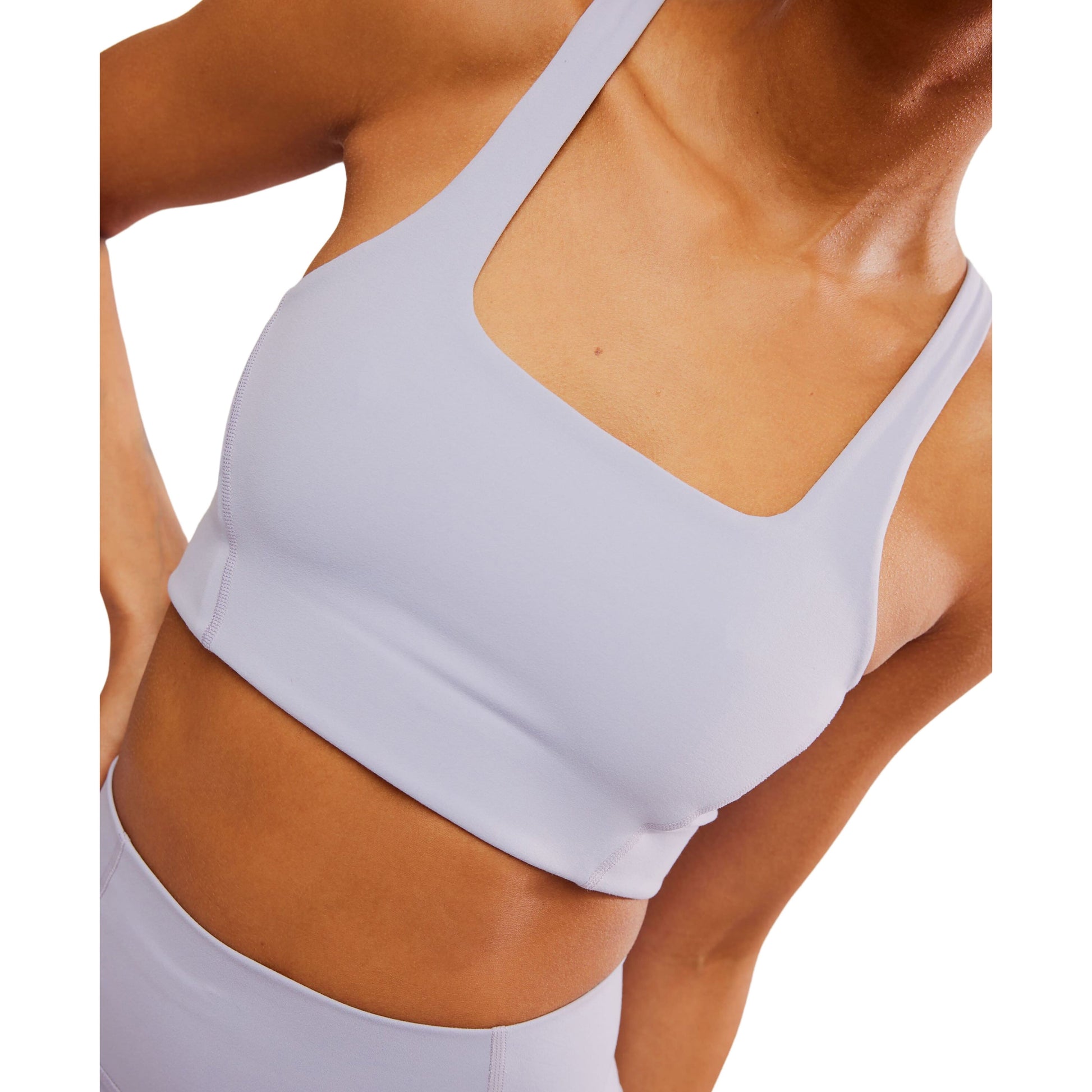 Close-up of a woman wearing a Free People Movement Never Better SQ Neck Bra in Platinum, with a breathable design, focusing on the upper body and abdomen.