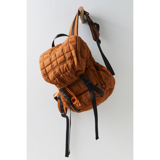 A quilted brown Summit Backpack with adjustable shoulder straps hanging on a white wall hook.