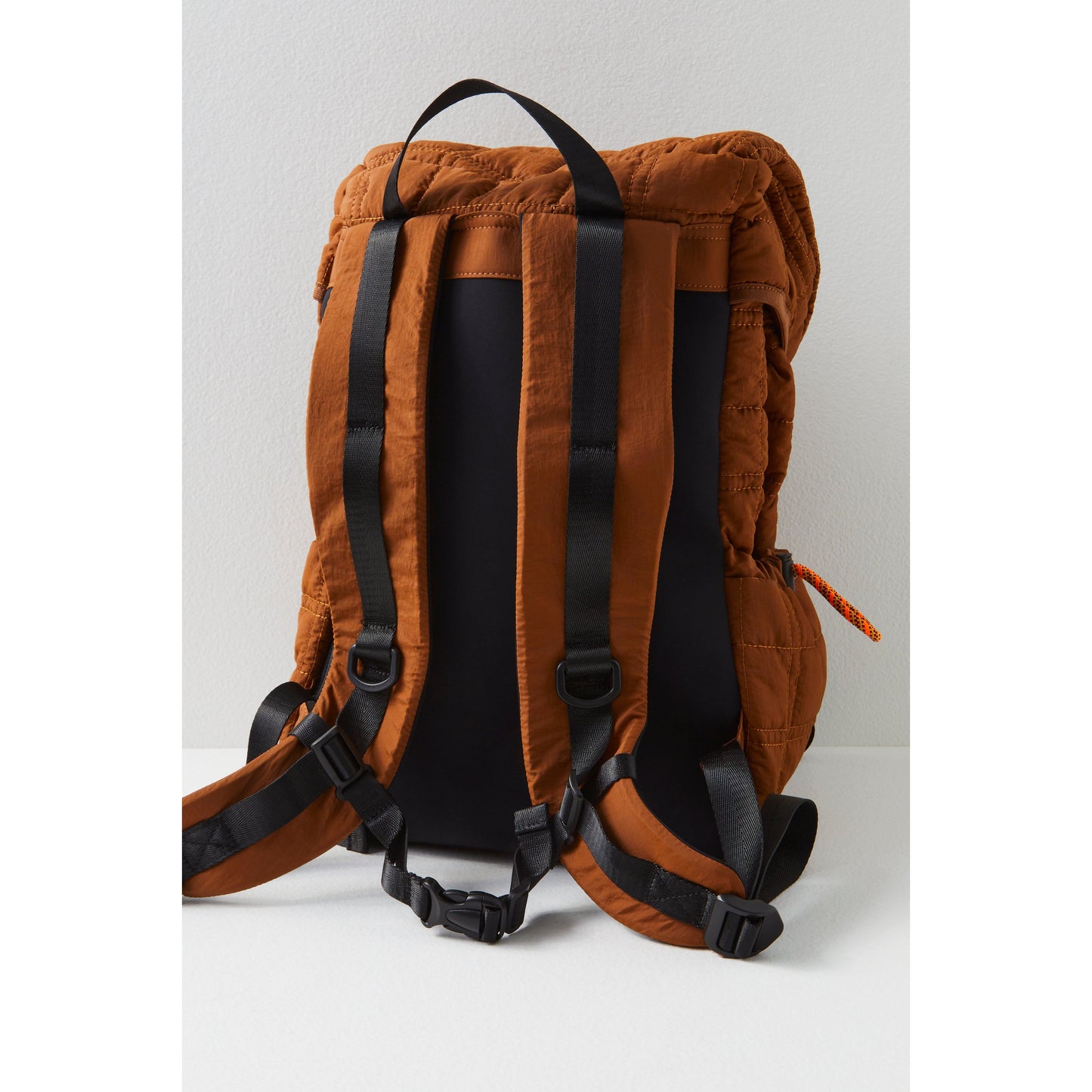 Brown Summit Backpack with padded straps and buckles, standing against a light gray background by Free People Movement.