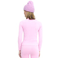 Dressed in a pink outfit and purple beanie, the person radiates an ultra-flattering appearance. Their ensemble features the Halfdays Johnson top, a nylon seamless base layer ideal for an active outdoor look.