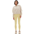 A person wearing a Halfdays Pieper Fleece jacket, yellow leggings, and beige sneakers stands against a white background.