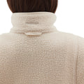 Rear view of a person wearing the Pieper Fleece by Halfdays, a cream-colored quarter-zip jacket with the collar up, highlighting its performance durability.