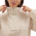A person wearing the Pieper Fleece from Halfdays, a light-colored Sherpa pullover with a quarter-zip, adjusts the collar with both hands.