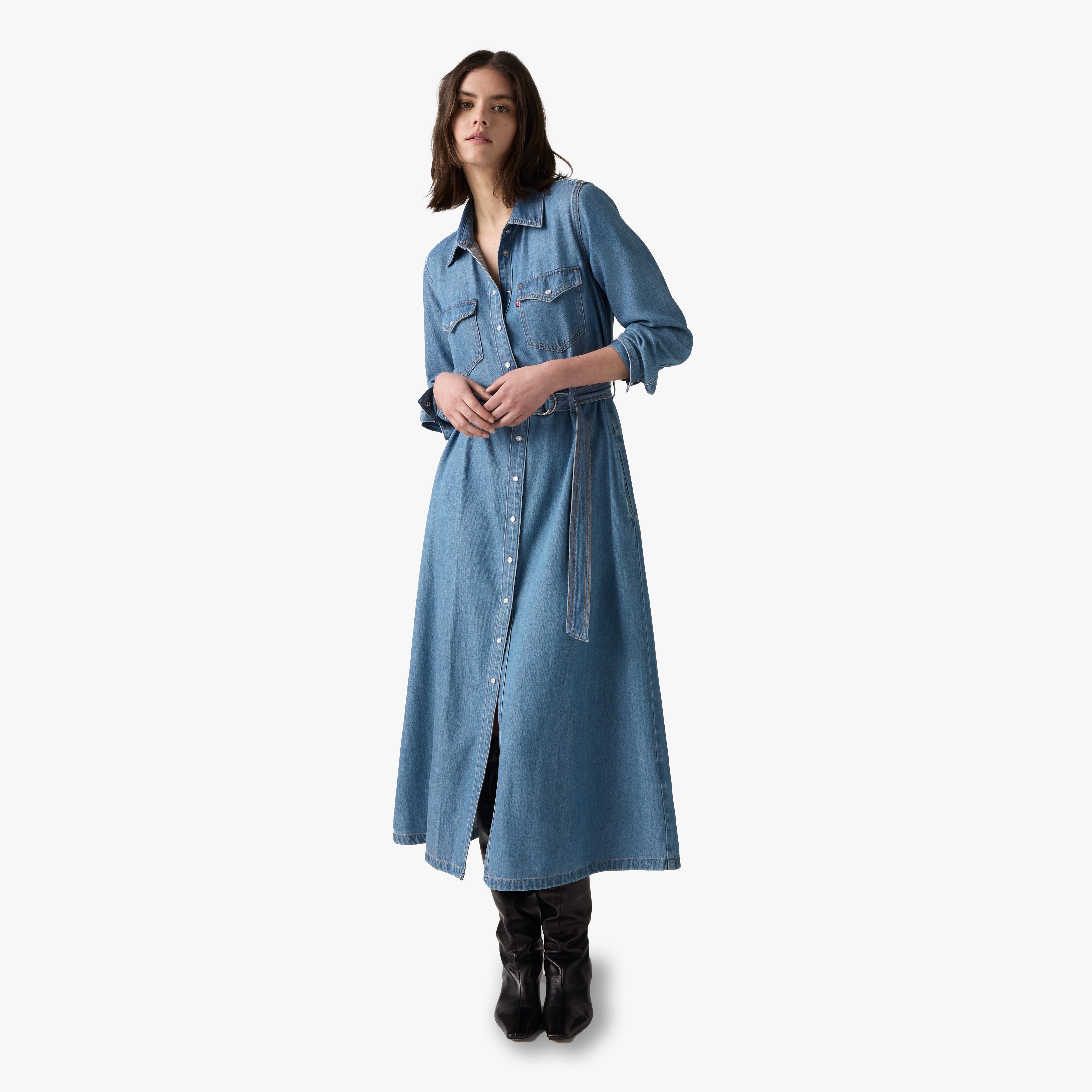 Woman wearing a long denim dress on a white background