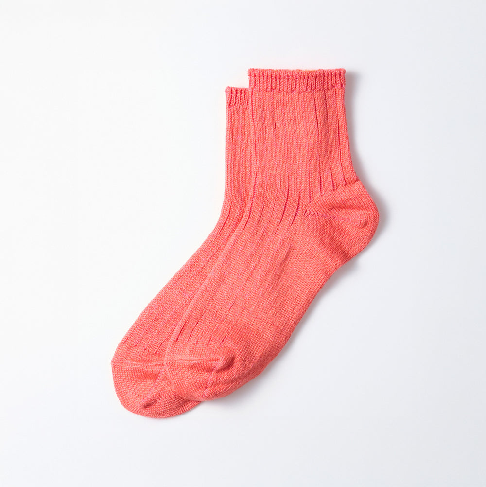 A single pink Everyday Pile Ankle Sock by RoToTo, featuring a ribbed pattern, lies flat on a white surface.