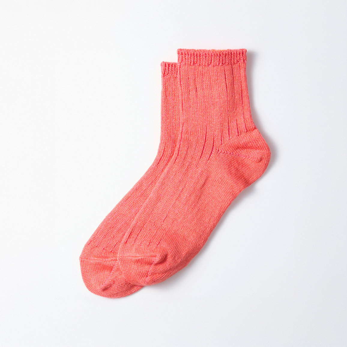A single pink Everyday Pile Ankle Sock by RoToTo, featuring a ribbed pattern, lies flat on a white surface.